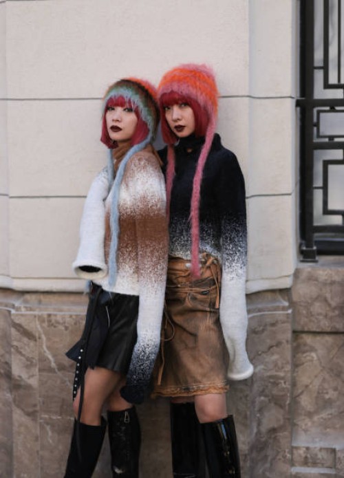 Twins Ami & Aya Amiaya were seen wearing black boots, a black and brown skirt, colorful hats and white and brown as well as white and black striped...
