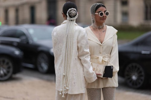 Twins Jyoti Babani, Snehal Babani seen wearing glasses decorated with pearls and crystals, head and hair accessories, and a creme white Chanel...