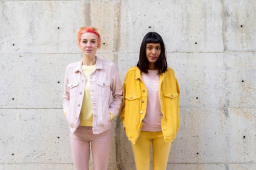 two alternative friends having fun, wearing yellow and pink jeans clothes - fashion stock pictures, royalty-free photos & images
