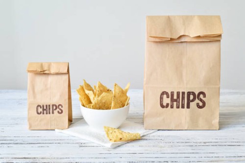 two bags of nacho chips in different sizes - junk food stock pictures, royalty-free photos & images