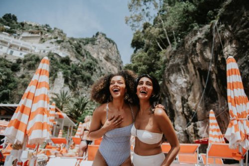 two beautiful young woman look thrilled to be standing on a sunny beach in paradise - travel stock pictures, royalty-free photos & images