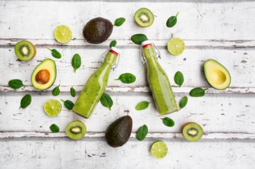 two bottles of green smoothie with avocado, spinach, kiwi and lime - junk food stock pictures, royalty-free photos & images