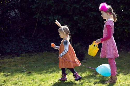 two children on easter egg hunt - garden decoration stock pictures, royalty-free photos & images
