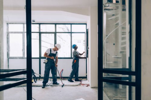 two construction workers working together on an apartment renovation - home decoration stock pictures, royalty-free photos & images