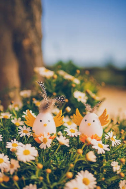 two cute handmade easter eggs in retro look as a sweet cockerel in a bloomy garden - garden decoration stock pictures, royalty-free photos & images