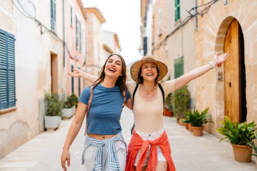 two female friends having fun on the street in alcúdia in mallorca in spain - travel stock pictures, royalty-free photos & images