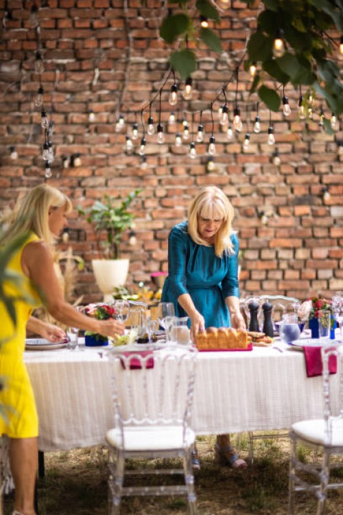 two female friends preparing dining table for dinner party at backyard - garden decoration stock pictures, royalty-free photos & images