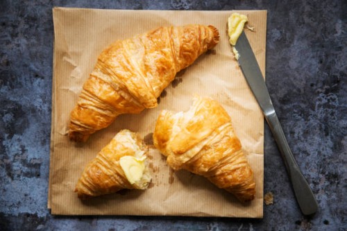 two freshly baked french croissants with butter and a knife - junk food stock pictures, royalty-free photos & images