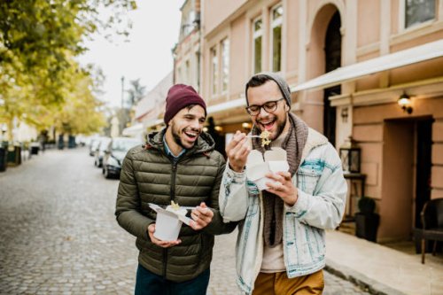 two friends eating fast food outdoors - junk food stock pictures, royalty-free photos & images