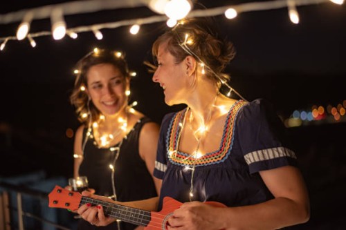 two friends enjoying night out at rooftop party - concert stock pictures, royalty-free photos & images