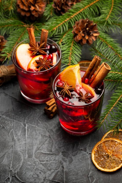 two glasses of christmas mulled red wine with decoration, orange, cinnamon and fir tree on rustic background - food stockfoto's en -beelden