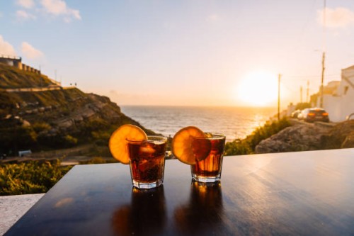 two glasses with cocktails at the table by the ocean during sunset - food stock pictures, royalty-free photos & images