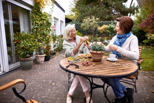 two happy senior women crafting at garden table - garden decoration stock pictures, royalty-free photos & images
