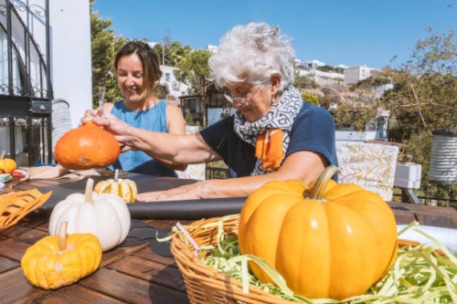 two ladies sitting in the garden and creating halloween decoration - garden decoration stock pictures, royalty-free photos & images