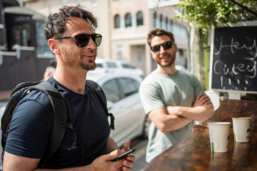 two men ordering food at market stall in the city - junk food stock pictures, royalty-free photos & images