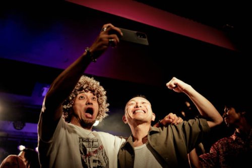 two men taking selfies with their cell phones at a live music club. - concert stock pictures, royalty-free photos & images