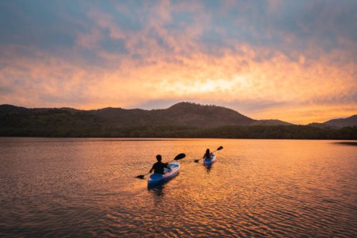 two people kayaking in a lagoon at sunset - travel stock pictures, royalty-free photos & images