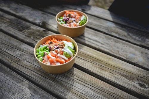 two poke bowls with raw organic ingredients on a wooden table outdoors. - junk food stock pictures, royalty-free photos & images