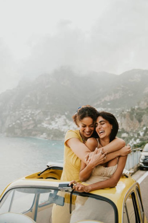 two woman enjoy experiential travel in a rented vintage car in italy. they hug. - travel stock pictures, royalty-free photos & images