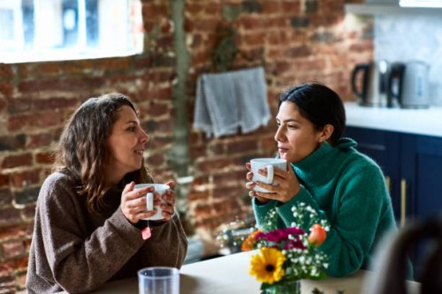 two women enjoying hot drink having conversation - coffee stock pictures, royalty-free photos & images
