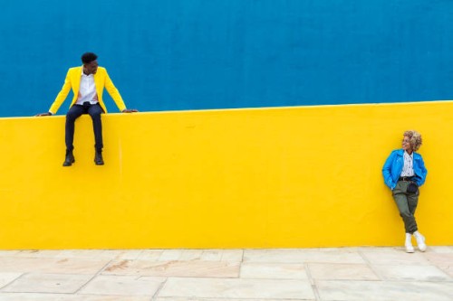 two young african friends keeping social distance over yellow and blue background. friendship and social relationship concept. copy space for text. banner template - fashion stock pictures, royalty-free photos & images
