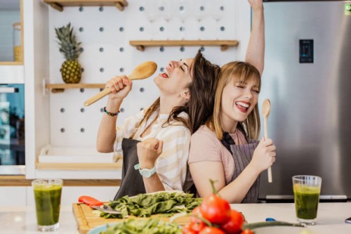 two young female friends cooking in the kitchen - food stock pictures, royalty-free photos & images