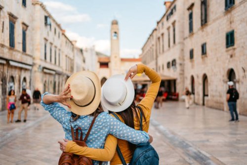 two young female friends embracing on the street in dubrovnik - travel stock pictures, royalty-free photos & images