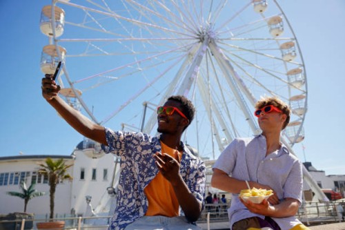 two young male adults taking having fun at the seaside - taking a selfie - junk food stock pictures, royalty-free photos & images