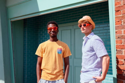 two young men posing outside in the sunshine wearing sunglasses and a hat - fashion stock pictures, royalty-free photos & images