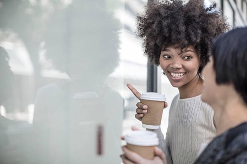 two young women with coffee looking through shop window - junk food stock pictures, royalty-free photos & images