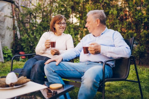 un couple profitant tout en étant assis dans le jardin - garden decoration photos et images de collection