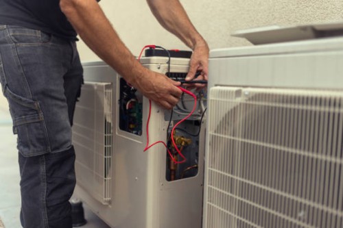 un electricista irreconocible instala una bomba de calor en el patio de un edificio residencial - home decoration fotografías e imágenes de stock