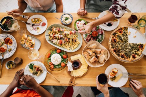 una vista desde arriba de una mesa llena de deliciosa comida consumida por un grupo irreconocible de personas multiétnicas - food fotografías e imágenes de stock