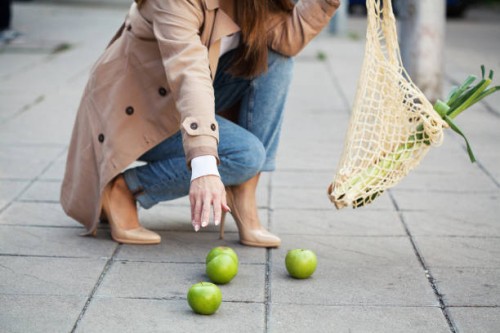 une jeune femme dépose des courses sur le trottoir - food photos et images de collection