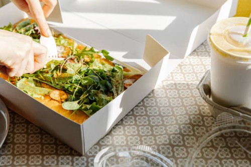 unrecognizable person cutting vegan dish in paper container - junk food stock pictures, royalty-free photos & images