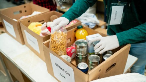 unrecognizable volunteer organizing donations in boxes wearing protective gloves - food stock pictures, royalty-free photos & images