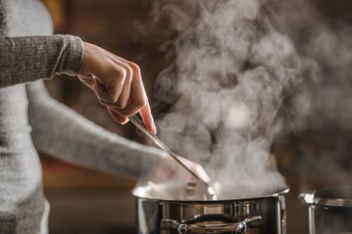 unrecognizable woman making lunch in the kitchen and stirring soup. - food stock pictures, royalty-free photos & images