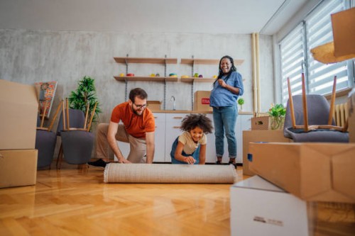 unrolling carpet in a new house - home decoration stock pictures, royalty-free photos & images