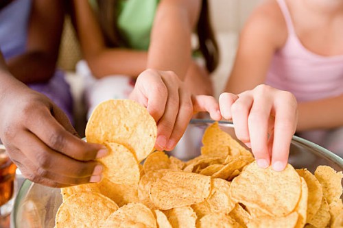 usa, california, los angeles, three girls (10-11) reaching for crisps - junk food stock pictures, royalty-free photos & images