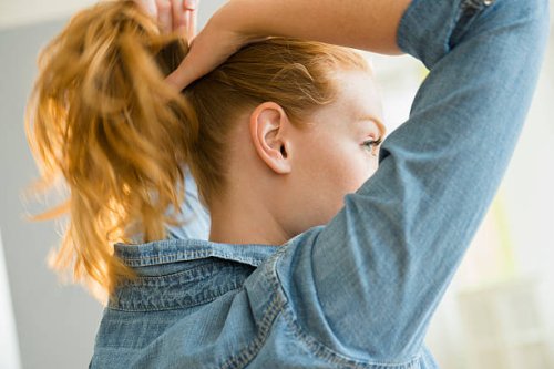 usa, new jersey, young woman tying hair - hairstyle stock pictures, royalty-free photos & images