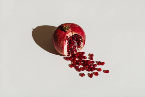 ut pomegranate on a white background. menstruation concept. symbol of vagina. gynecology, female intimate health - food stockfoto's en -beelden