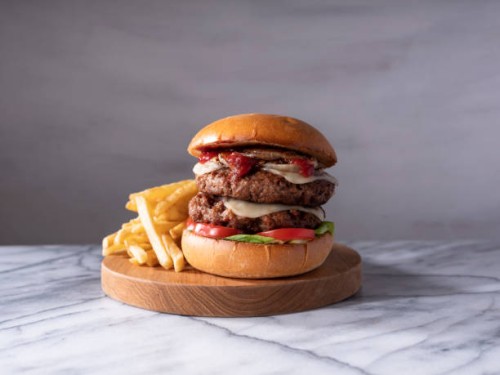 vegan double cheeseburger on light marble counter top. - junk food stock pictures, royalty-free photos & images