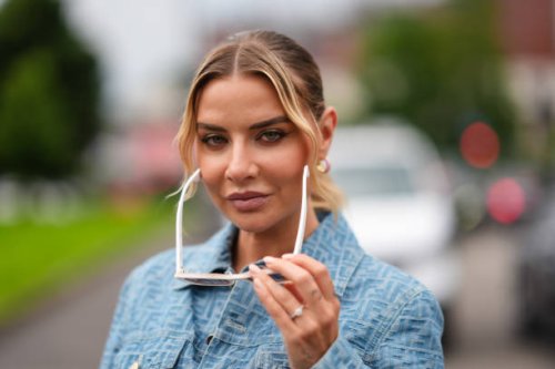 Veronica Ferraro wears sunglasses, a blue denim jacket with printed monograms, outside Fendi, during the Milan Fashion Week Menswear Spring/Summer...