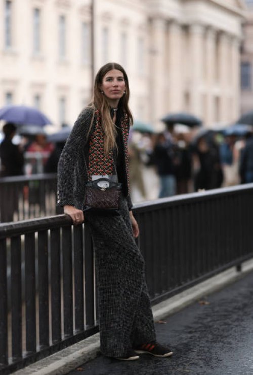 Veronika Heilbrunner is seen outside Chanel show wearing pearl earrings, grey tweed jacket and matching Chanel pants, burgundy and black crossbody...