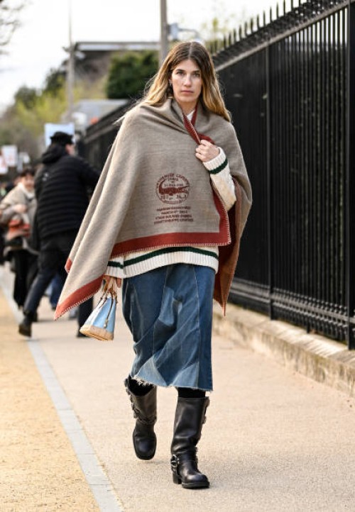 Veronika Heilbrunner is seen wearing a Lacoste blanket, cream and black sweater, blue jeans and black boots with tan and light blue bag outside the...