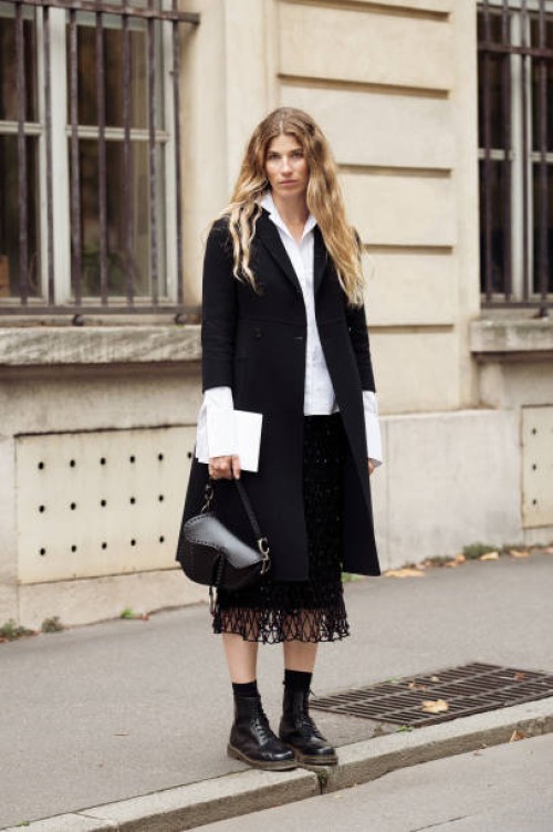 Veronika Heilbrunner wears white shirt, black fish net skirt, black coat, black socks, black loafer and black Dior bag outside the Dior show during...