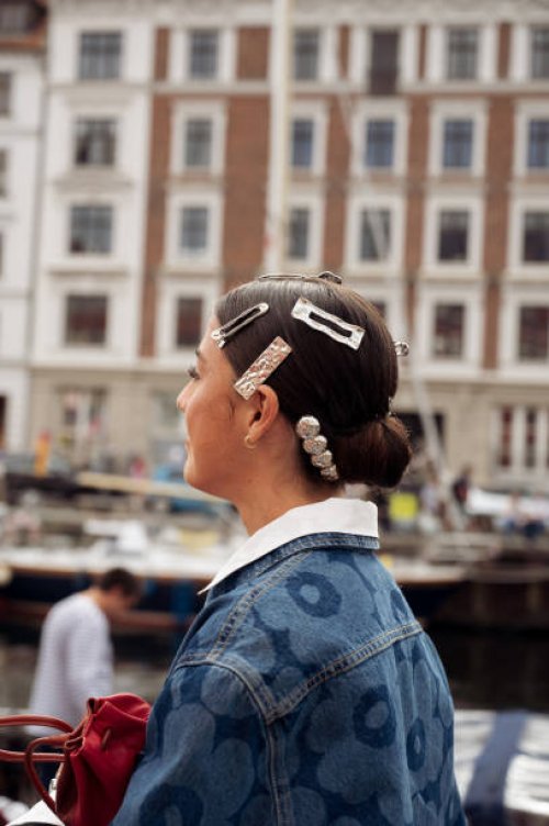Vicky Montanari wears blue denim shirt, red bag and hair clips attends VIP guest trip with a boat to the Marimekko show during day four of the...