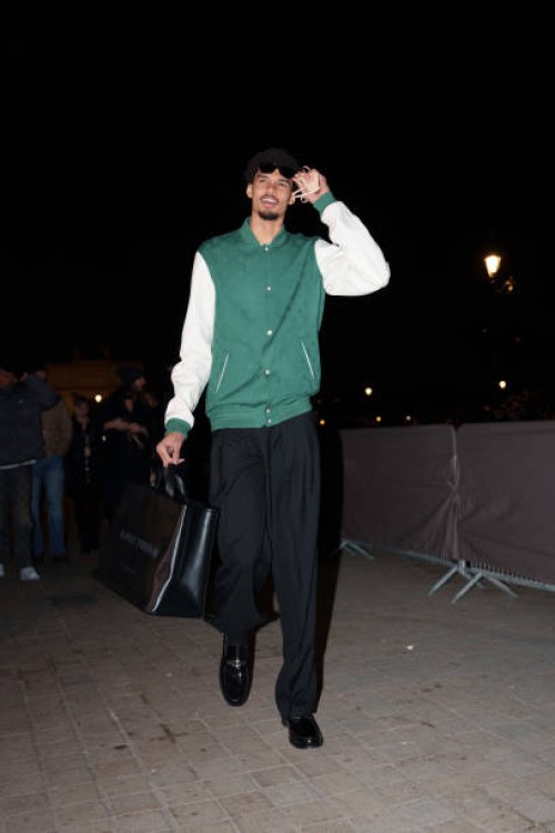 Victor Wembanyama wears sunglasses, a green and white teddy jacket with monogram logo print from Louis Vuitton, black flared pants, black leather...