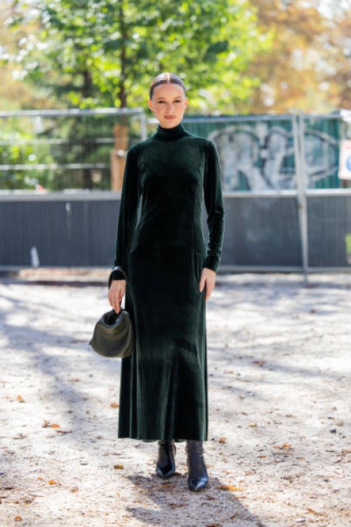 Victoria Magrath wears green velvet dress, bag, black boots outside Akris during the Womenswear Spring/Summer 2024 as part of Paris Fashion Week on...