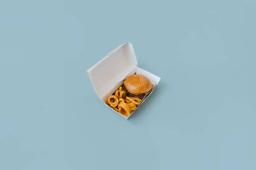 view of a hamburger and fries with open box on light blue plain background. - junk food stock pictures, royalty-free photos & images